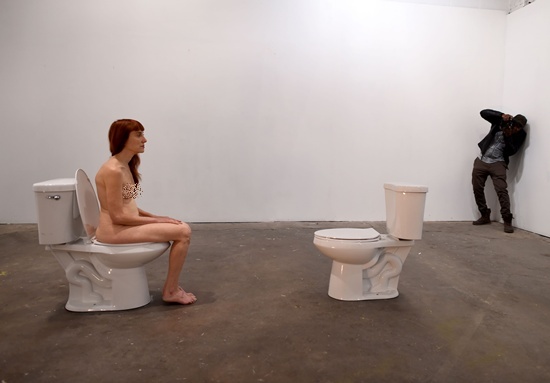 New York, State of New York: Graphic content/Conceptual artist and comedian Lisa Levy is photographed nude on a toilet facing a another unoccupied toilet during Levys performance art show titled “The Artist Is Humbly Present” at the Christopher Stout Gallery January 31, 2016 in the Bushwick section of New York. AFP/Timothy A. Clary 