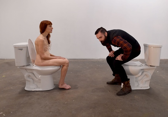New York, State of New York: Graphic content/Conceptual artist and comedian Lisa Levy (L) sits nude on a toilet facing participant Eric Gottshall during Levys performance art show titled “The Artist Is Humbly Present” at the Christopher Stout Gallery January 31, 2016 in the Bushwick section of New York. AFP/Timothy A. Clary
