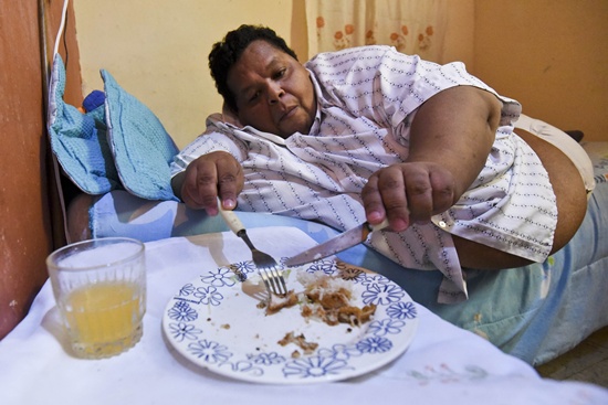 PALMIRA, Valle del Cauca, COLOMBIA: Oscar Vasquez Morales (L), 44, eats lunch at his home on March 19, 2016, in Palmira, Colombia. AFP PHOTO/Luis Robayo