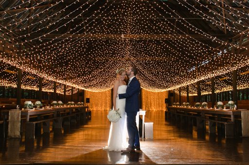 This Sept. 2015 photo provided by Mandee Morgan shows Mandee and Thor Morgan during their wedding reception at Camp Highlander in Horse Shoe, N.C. Summer-camp weddings are a hot new twist on the destination wedding. (Amy Martin Photography/Mandee Morgan via AP)