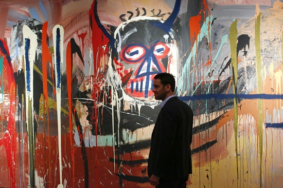 New York, State of New York: Loic Gouzer Deputy Chairman, Post-War and Contemporary at Christies stands next to the artwork Untitled made by artist Jean-Michel Basquiat on April 29, 2016 during a press preview of Christies forthcoming evening auctions of the Contemporary, Impressionist, Modern and Post-War Art in New York. As part of the 20th Century season in New York, the Post-War and Contemporary Art Evening Sale takes place on 12 May, featuring some of the leading modern masters and contemporary stars of today. AFP/Kena Betanbur
