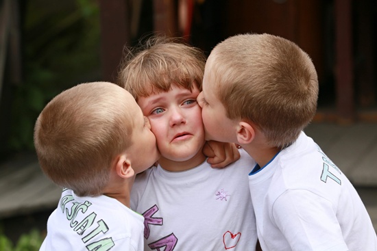 Zvole, Czech Republic: 10 years old triplets Josef, Katerina And Daniel (L toR) hug each other during a meeting of twins and multiples in Zvole, Czech Republic, south Moravia, on May 29, 2016. AFP/Radek Mica