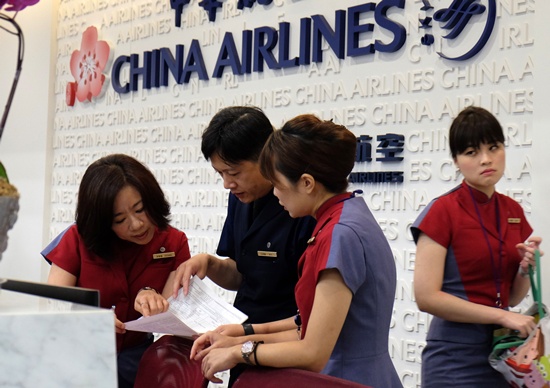 Taipei: Ground employees of China Airline check the latest informations at the front desk as their fly attendees on strike in Taipei on June 24, 2016. A strike by staff from Taiwans largest carrier China Airlines left 20,000 passengers without flights in the first industrial action by cabin crew in the islands aviation history. AFP/Sam Yeh