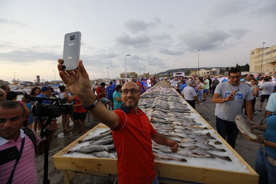 Batroun, Lebanon: A man takes a selfie near a display of fish as members of Lebanons Batroun Traders Association break a Guinness World Record for the largest seafood display, on September 4, 2016 in the Mediterranean coastal town of Batroun. AFP/Anwar Amro