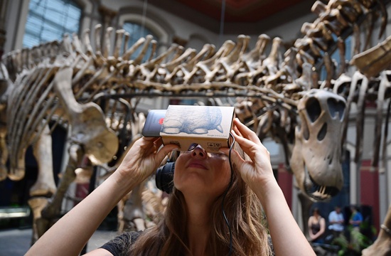 Berlin: A woman uses a smartphone equipped with a so-called Google Cardboard mount to use it as a VR (virtual reality) device for trying out a new offer developed by Googles platform Google Arts & Culture and the Museum of Natural History (Naturkundemuseum) in Berlin on September 13, 2016 at the museum. AFP/Tobias Schwarz