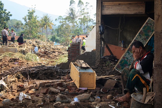 Garut, West Java, Indonesia: A villager mourns outside his house after a landslide in Garut on September 21, 2016. The death toll from a series of landslides and flash floods in Indonesia climbed to 19 on September 21, an official said, including several children found by rescuers scouring for survivors. AFP/Luly