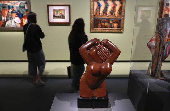 Paris: Visitors stand next to the wooden sculpture Nude woman by Mexican sculptor Luis Ortiz Monasterio during the exhibition Mexique : Diego Rivera, Frida Kahlo, Jose Clemente Orozco et les avant-gardes on October 6, 2016 at the Grand Palais museum in Paris. The exhibition will run until January 23, 2017. AFP/Jacques Demarthon