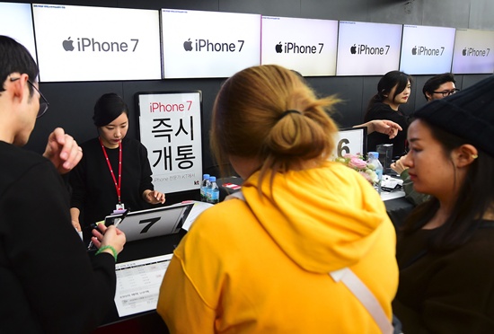 Seoul: People buy new iPhone models at a telecom shop in Seoul on October 21, 2016. Apple released for sale its new iPhone 7 and 7 Plus in South Korea on October 21. / AFP / JUNG YEON-JE