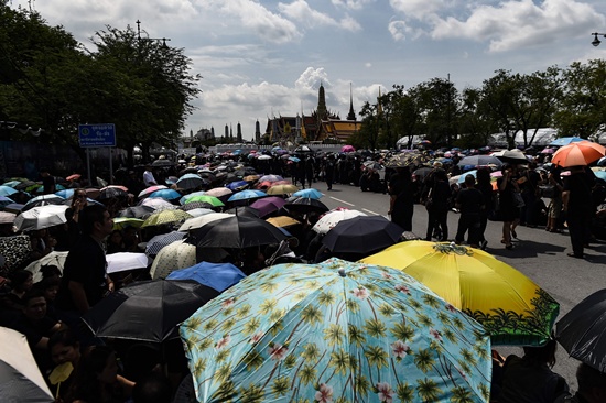 Bangkok: Thousands of mourners clad in black shelter under umbrellas in front of the Grand Palace whilst paying respects to the late Thai King Bhumibol Adulyadej in Bangkok on October 22, 2016. Thailands King Bhumibol Adulyadej died at the age of 88 on October 13 after years of ill health, ending a seven-decade reign and leaving the politically divided nation without its key pillar of unity. AFP/Lillian Suwanrumpha