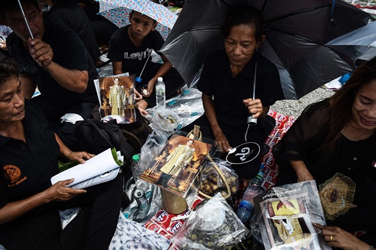 Bangkok: Mourners clad in black sit in Sanam Luang park next to the Grand Palace with images of the late Thai King Bhumibol Adulyadej in Bangkok on October 22, 2016. Thailands King Bhumibol Adulyadej died at the age of 88 on October 13 after years of ill health, ending a seven-decade reign and leaving the politically divided nation without its key pillar of unity. AFP/Lillian Suwanrumpha