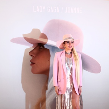 Tokyo: US singer Lady Gaga poses for photographers in front of her new album cover during a photo call to promote the album Joanne in Tokyo on November 2, 2016. AFP/Behrouz Mehri