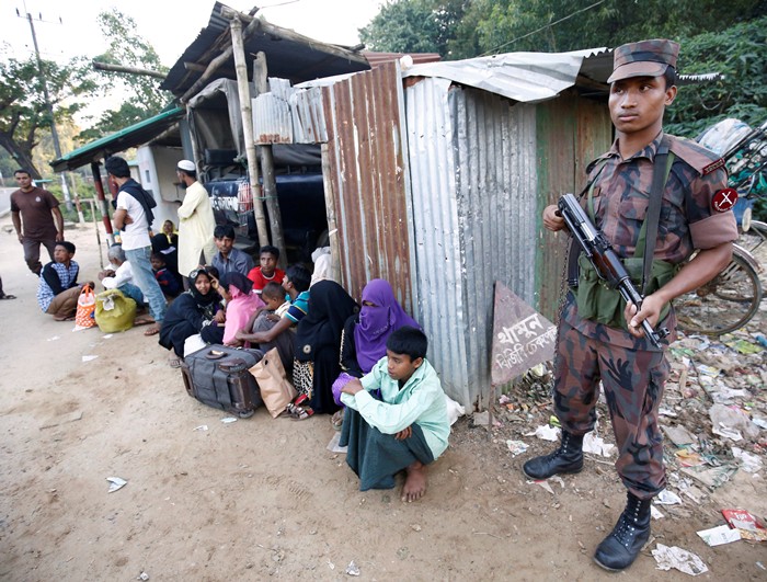 <br><FONT color=#000033>เจ้าหน้าที่รักษาความมั่นคงยืนคุมกลุ่มชาวมุสลิมโรฮิงญา 38 คน ที่จับตัวได้หลังลักลอบข้ามแดนพม่า-บังกลาเทศ ที่ด่านชายแดนในเมืองคอกซ์ บังกลาเทศ เมื่อวันที่ 21 พ.ย. -- Reuters/Mohammad Ponir Hossain.</font></b>