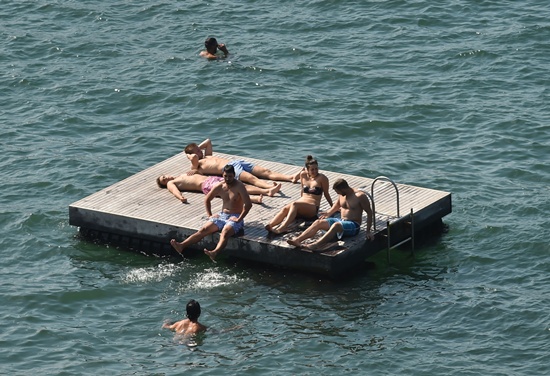 Sydney: People cool off on a pontoon and in the water in the harbour as temperatures soared in Sydney on November 22, 2016. AFP/Peter Parks