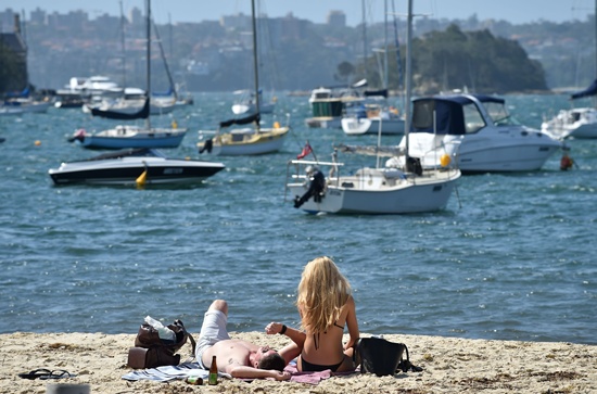 Sydney: A couple sits on a harbour beach as temperatures soared in Sydney on November 22, 2016. AFP/Peter Parks