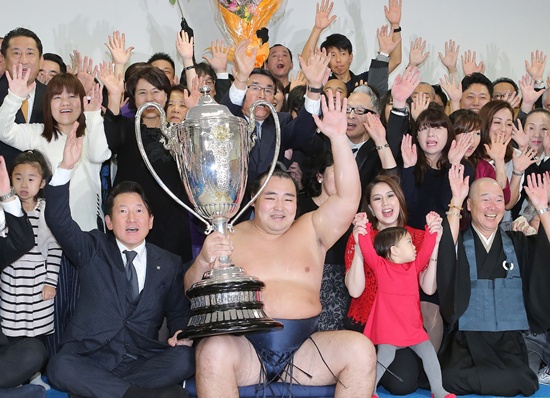 Fukuoka, Japan: Mongolian-born yokozuna, or grand champion, Kakuryu (C) poses with his supporters as he holds the Emperors Cup after the awarding ceremony in Fukuoka on November 27, 2016, the last day of the 15-day Kyushu grand sumo tournament. AFP/Jiji Press/STR
