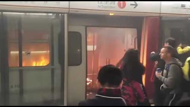 เพลิงไหม้ขบวนโดยสารรถไฟใต้ดิน จากระเบิดเพลิง ที่คนร้ายก่อเหตุฯ เมื่อจอดสถานีจิมซาจุ่ย ขณะที่มีคนแน่นในขบวนดังกล่าว จนมีผู้ได้รับบาดเจ็บอย่างน้อย 19 คน (ภาพจากคลิปฯ)