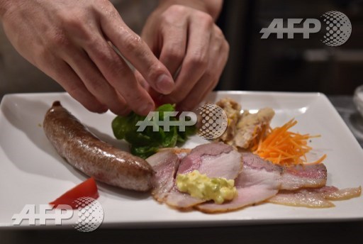 This picture taken on June 19, 2015, shows a chef serving a plate of assorted Mangalica pork meat at a restaurant in Tokyo. Mangalica is a rare Hungarian bred species of pig. AFP PHOTO/Yoshikazu Tsuno