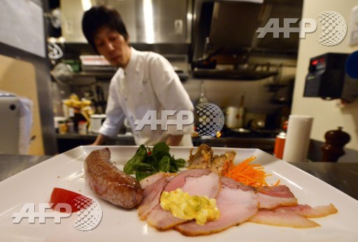 This picture taken on June 19, 2015, shows a chef serving a plate of assorted Mangalica pork meat at a restaurant in Tokyo. Mangalica is a rare Hungarian bred species of pig. AFP PHOTO/Yoshikazu Tsuno 