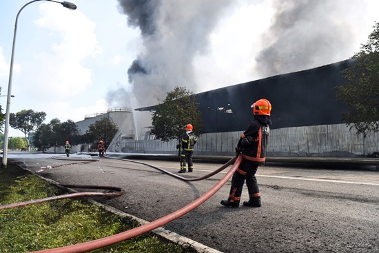Singapore: Firefighters from the Singapore Civll Defence Force (SCDF) extinguish a fire at a waste management plant in Singapore on February 23, 2017. AFP/Roslan Rahman