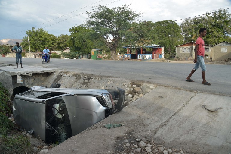 รถยนต์คันหนึ่งซึ่งถูกรถบัสตีนผีในเฮติพุ่งชนจนตกลงไปข้างทาง 