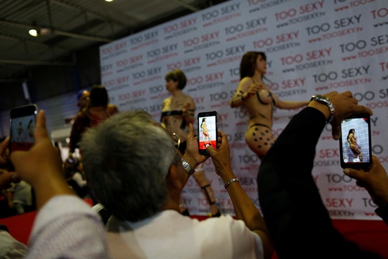 Dancers perform on a stage as visitors take pictures at the Expo Sex and Eroticism adult exhibition in Mexico City, Mexico March 3, 2017. REUTERS/Carlos Jasso