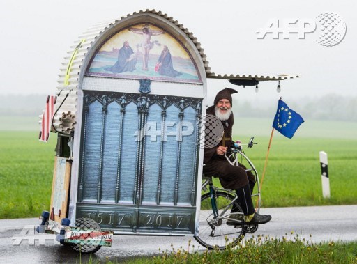 German bicycle enthousiast Dieter Didi Senft presents his latest creation, a self-designed Luther-Mobil, on a road near Sieversdorf, northeastern Germany, on May 4, 2017. Patrick Pleul/dpa/AFP