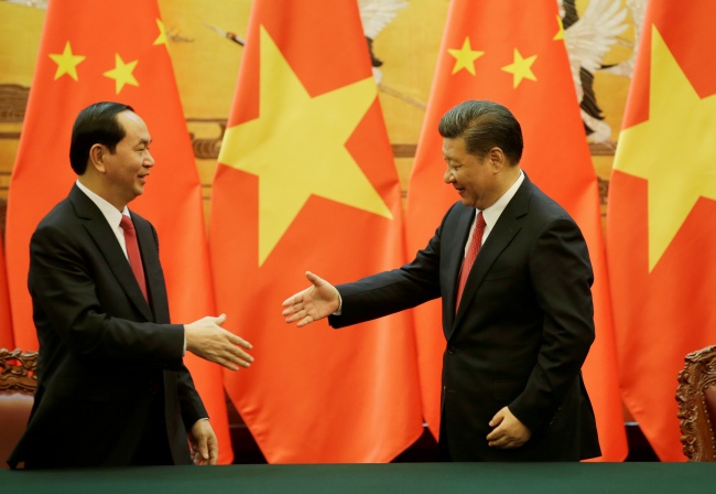<br><FONT color=#000033>ประธานาธิบดีเจิ่น ได กวาง ของเวียดนาม (ซ้าย) ยื่นมือไปสัมผัสกับประธานาธิบดีสี จิ้นผิง ของจีน ระหว่างพิธีลงนามที่มหาศาลาประชาชนในกรุงปักกิ่ง วันที่ 11 พ.ค. -- Reuters/Jason Lee.</font></b>