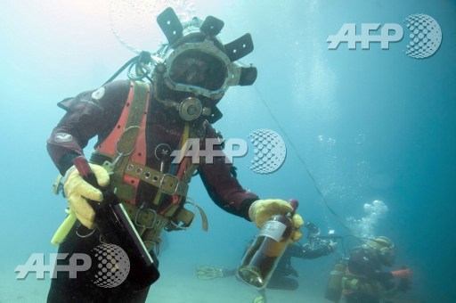 A diver shows bottles after taking it from an underwater wine cellar in the mediterranean sea off Saint-Mandrier, southern France on May 15, 2017. Boris Horvat/AFP