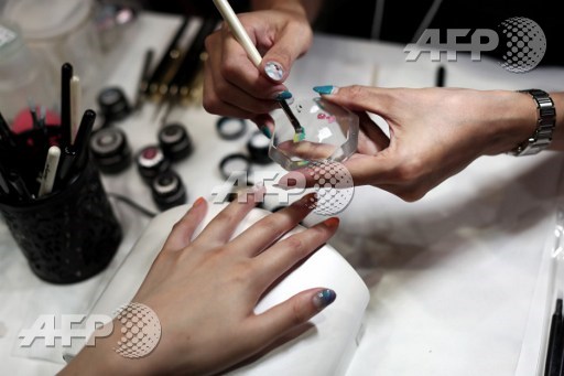 In this picture taken on October 30, 2016 a Japanese woman gets a manicure during the Nail Art Forum in Tokyo. Behrouz Mehri/AFP