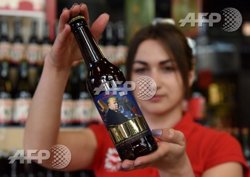 An employee shows a bottle of just brewered lager beer called Trump on which is depicted a portrait of US President Donald Trump and written President of Devided States of America on May 20, 2017 at the Pravda brewery-shop in the western Ukrainian city of Lviv. Yuri Dyachyshyn/AFP