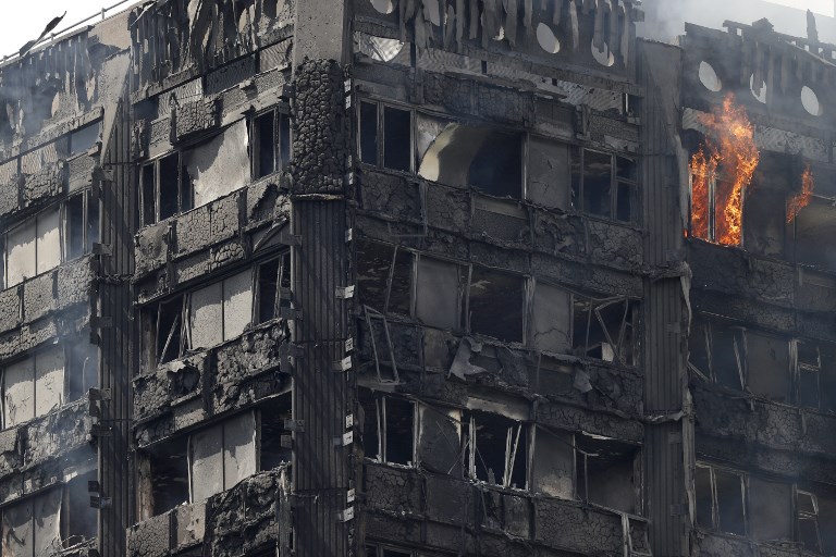 <i>ไฟยังคงไหม้อาคารที่พักอาศัย “เกรนเฟลล์ ทาวเวอร์” ในกรุงลอนดอน ช่วงกลางวันของวันพุธ (14 มิ.ย.) </i>
