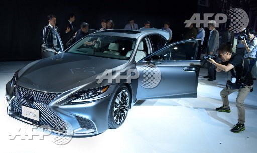 Photographers and journalists look at an all-new Lexus LS equipped with newly developed prevention safety technologies during a press conference in Tokyo on June 26, 2017. Toru Yamanaka/AFP