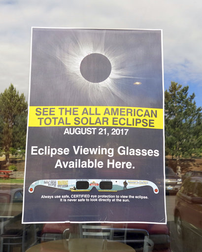A poster advertising the Aug. 21 total solar eclipse hangs in the window of a McDonalds restaurant in Madras, Oregon on June 12, 2017. (AP Photo/Gillian Flaccus)