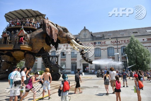 Children look at a mechanical elephant made of wood and steel at Les Machines de LIle (Machines of the Isle of Nantes) in Nantes, western France, on June 20, 2017. Loic Venance/AFP