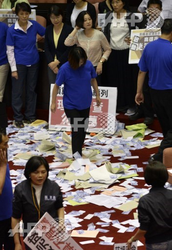 Legislators from the main opposition Kuomintang (KMT) and People First Party (PFP) stand on the budget papers of the forward-looking project during a demonstration at the Parliament in Taipei on July 13, 2017. Two Taiwanese lawmakers tried to choke each other during a brawl in the islands parliament on July 13 as the government of President Tsai Ing-wen pressed ahead with controversial reforms. Sam Yeh/AFP