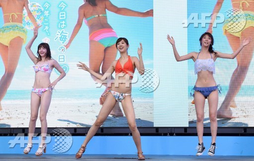 Models wearing new bikinis perform a promotional flash mob dance on stage in Tokyo on July 17, 2017. The event was organized by the Japan Swimsuit Association to promote the latest swimsuits. Kazuhiro Nogi/AFP