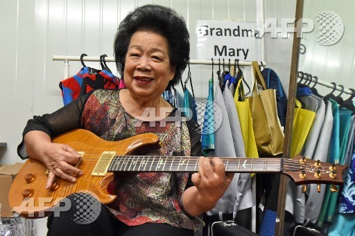 This picture taken on August 5, 2017 shows Mary Ho, also known as Grandma Mary, posing with her electric guitar during a rehearsal in Singapore. An 81-year-old guitar-slinging Singaporean granny has shredded stereotypes to pursue her love of rock music, becoming a sought-after performer and unlikely internet sensation. Mary Hos late-flourishing career will reach its zenith on August 9 when she performs in front of a huge crowd at Singapores National Day Parade, marking 52 years of the city-states independence. Roslan Rahman/AFP