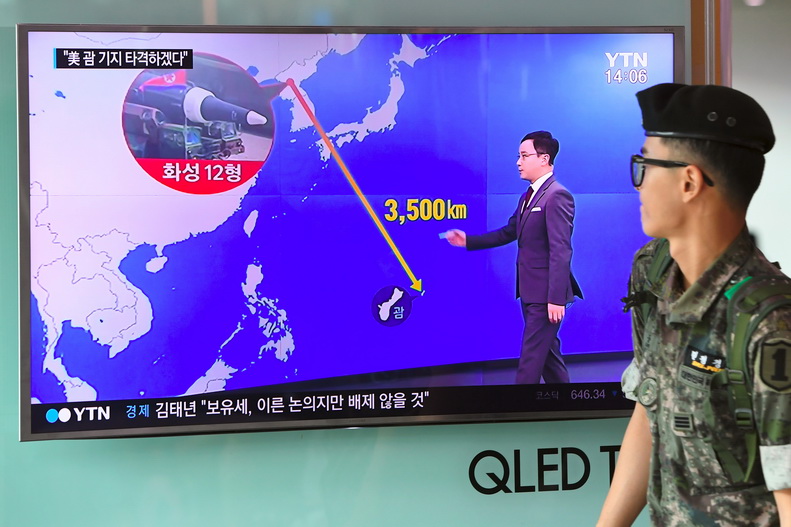 หน้าจอโทรทัศน์ภายในสถานีรถไฟกรุงโซลขึ้นภาพกราฟฟิกแสดงระยะทางระหว่างเกาหลีเหนือกับเกาะกวม เมื่อวันที่ 9 ส.ค. 