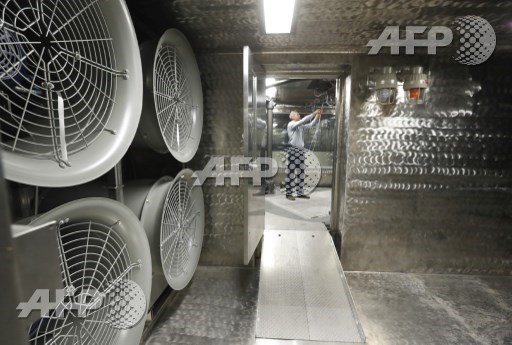 DUGWAY, UT: Large fans hang on a wall as chief of the Chemical Test Branch Adam Rogers checks out a wiring harness in a wind tunnel testing room at the small item decontamination testing chamber facility at the U.S. Armys Dugway Proving Ground on August 15, 2017 in Dugway, Utah. George Frey/Getty Images/AFP 