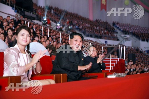 (FILES) This undated file picture released by North Koreas official Korean Central News Agency (KCNA) on October 19, 2015 shows North Korean leader Kim Jong-Un (C), accompanied by his wife Ri Sol-Ju (L), enjoying a joint performance by the state merited chorus and the Moranbong band for celebrating the 70th founding anniversary of the Workers Party of Korea (WPK) at the Ryugyong Chung Ju-yung gymnasium in Pyongyang. STR/KCNA via KNS/AFP