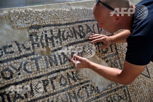 An archaeologist works on part of a 1,500-year-old mosaic floor bearing the names of Byzantine Emperor Justinian, at the Rockefeller Museum in Jerusalem, on August 23, 2017, after they unearth a portion of ancient mosaic near the citys Damascus Gate. Ahmad Gharabli/AFP