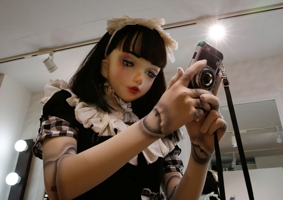 Doll model Lulu Hashimoto uses a smart phone to answer a question during an interview with Reuters in Tokyo, Japan August 23, 2017. Picture taken August 23, 2017. REUTERS/Kim Kyung-Hoon