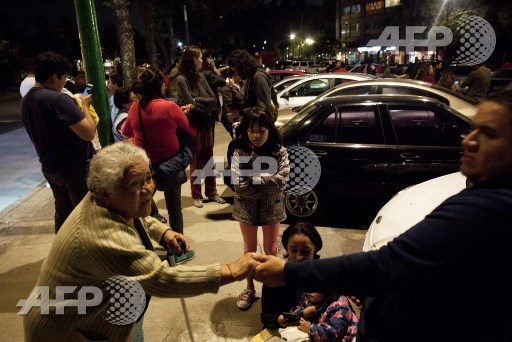 People react on a street in the Tlatelolco neigborhood of Mexico City during an earthquake on September 7, 2017. An earthquake of magnitude 8.0 struck southern Mexico late Thursday and was felt as far away as Mexico City, the US Geological Survey said, issuing a tsunami warning. It hit offshore 120 kilometers (75 miles) southwest of the town of Tres Picos in the state of Chiapas. Pedro Pardo/AFP
