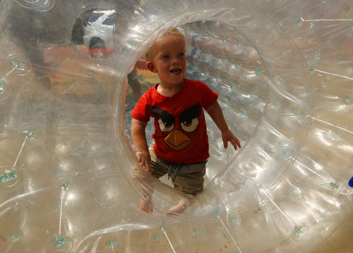 Winner of a Mr. Dwarf competition, Adriaan Coetzee, plays in a plastic air bubble during a weekend dwarf festival in Modimolle, South Africa, Saturday, Sept. 9, 2017. (AP Photo/Denis Farrell)