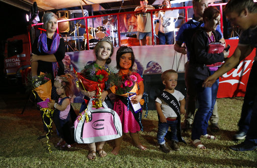 Winners of a Mr. and Ms. Dwarf competition, Adriaan Coetzee, right, Naline Kruger, first princess, center and Bernadine Coetze, left, during a weekend dwarf festival in Modimolle, South Africa, Friday, Sept. 8, 2017. (AP Photo/Denis Farrell)