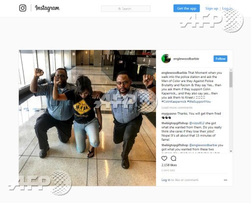 An image grab of the Instagram page of Aleta Clark (englewoodbarbie) shows Clark posing in a picture she posted on September 24, 2017 with two uniformed Chicago police officers kneeling with one hand raised in a fist at a police station in Chicago. Handout/Aleta Clark/AFP
