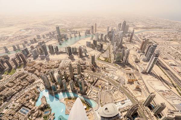 นักท่องเที่ยวแห่ไปยังตึกระฟ้าบุรจญ์เคาะลีฟะฮ์ที่สูงที่สุดในโลกด้วยความสูง 828 เมตร เพื่อชมทัศนียภาพมุมสูงเช่นที่เห็นนี้  โครงการพัฒนาหลายแห่งในเขตเมืองหาทางลดระดับความสูงลง  เช่น โรงละครโอเปรา (ตรงกลาง ด้านล่าง) เป็นส่วนหนึ่งของเขตพื้นที่ระดับพื้นดินที่วางแผนให้เป็นย่านคนเดิน  และเชื่อมต่อกับรถโดยสารสาธารณะในเมืองที่ยังพึ่งพาการใช้รถยนต์ เป็นหลัก