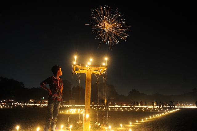 เด็กชาวอินเดียคนหนึ่งมองดูดอกไม้ไฟที่สนามกีฬามาดันโมฮันมัลวิยาในระหว่างเทศกาลดิวาลีในเมืองอัลลาฮาบัด (18 ก.ย.)