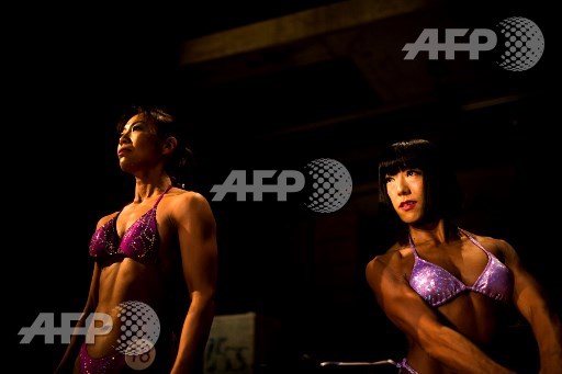 In this picture taken on October 9, 2017, Japanese bodybuilders Yukiko Yuasa (L) and Junko Hattori wait to go on stage during the Japan bodybuilding championships in Tokyo. Behrouz Mehri/AFP