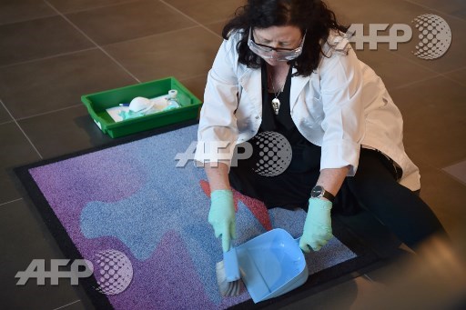 This photo taken on September 28, 2017 shows Australian space archaeologist Alice Gorman sweeping the Cosmic Welcome Mat for space particles at the entrance to the 68th International Astronautical Congress 2017 in Adelaide. Peter Parks/AFP